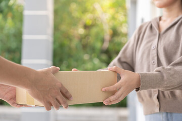 woman receives boxes parcel from courier in front house. Delivery man send deliver express. online...