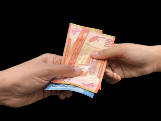 Money. Cash. Notes, Currency being given and received. Isolated on black Back ground.