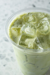 A closeup view of a iced cold matcha latte.