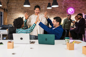 Excited business team celebrating success in modern office