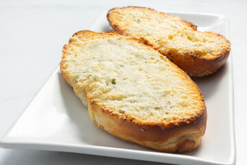 A view of garlic bread, on a plate.