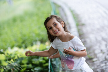 Smiling girl playing with leaves in a park