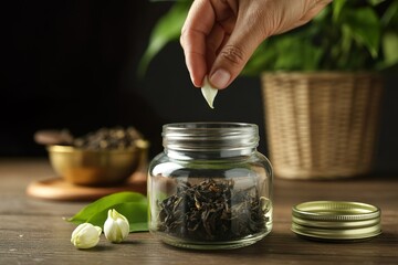 hand add jasmine flower into tea jar for good scent