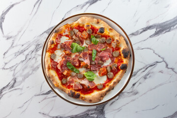 A top down view of an Italian meaty pizza.