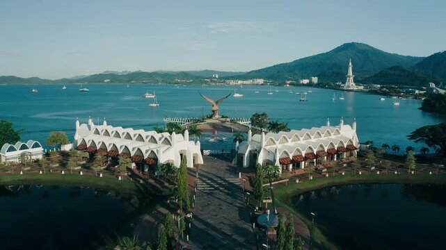 March 11th, 2022 - Langkawi, Malaysia: 4k Establishing b-roll aerial shot of drone moving backward Eagle Square (Dataran Lang). Flying over Kuah jetty waterfront. Beautiful tropical island land