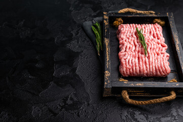 Fresh minced pork meat, raw mincemeat in wooden tray. black background. top view