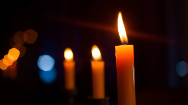 Candlelight Serenade: A close-up shot of three candles illuminating a dimly lit space, the soft glow evokes a sense of peace and tranquility. 