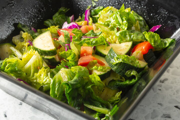 A closeup view of a garden salad in a large bowl.