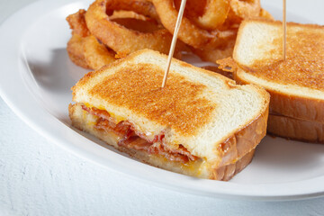 A closeup view of a bacon and grilled cheese sandwich.