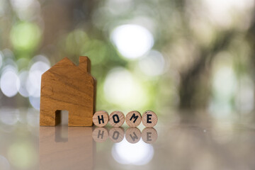 House model with spelling the word home on wood circle block. Mortgage for a home, Real estate concept.