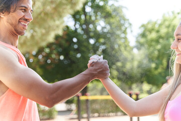 Athletes shaking hands after applying climbing chalk in park