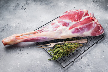 Raw whole goat leg, fresh meat. grey background. top view