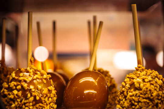 Caramel toffee apples on sticks on a food stall, close up