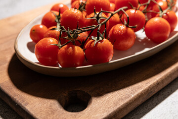 Closeup of fresh cherry tomatoes served on a dish with cast shadow