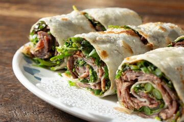 A closeup view of scallion pancake beef rolls.