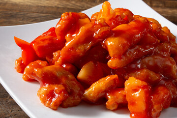 A closeup view of a plate of sweet and sour chicken.