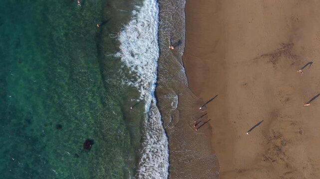 Aerial drone footage revealing scenic Las Canteras urban beach, showcasing vibrant coastline, crystal waters, and bustling waterfront landscape in Las Palmas, Gran Canaria