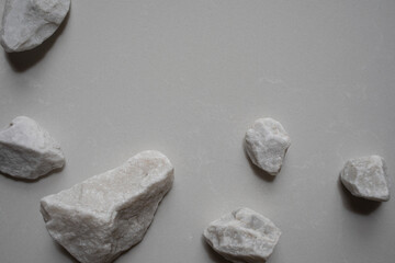 Aesthetic composition with white decorated stones on neutral background for minimalistic template in flat lay style.