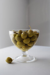 Glass bowls with marinated olives on stone table. Mediterranean snack or appetizer.
