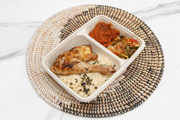 Cuisse de poulet accompagnée d’attiéké – plat à emporter de style antillais
