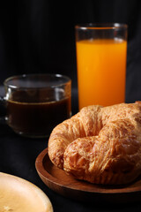 Breakfast of coffee cup orange juice and croissant