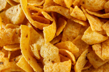 A top down view of a pile of corn chips, as a background.