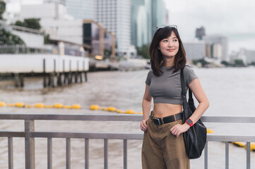 Happy solo Southeast Asian woman teenager blogger and world travel explorer wait for an express...