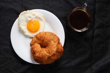 Breakfast of coffee cup egg and croissant