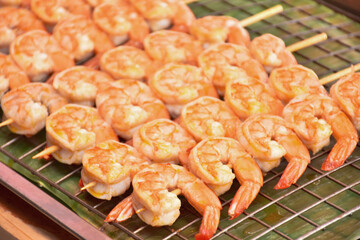 Grilled fried Prawns on skewers on metal grid baking sheet background