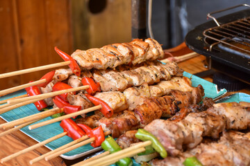 Grilled pork shashlik kebabs on barbecue outdoors at back yard. Meat lamb kebab on BBQ. Barbecue shish kebab at outdoor picnic top view, selective focus, series.