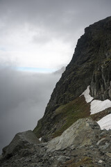 Clouds over the valley, a journey along a trail in the high mountains.
