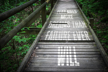 Inspirational Quote on Wooden Bridge in Forest Encouraging Courage Over Fear and Failure