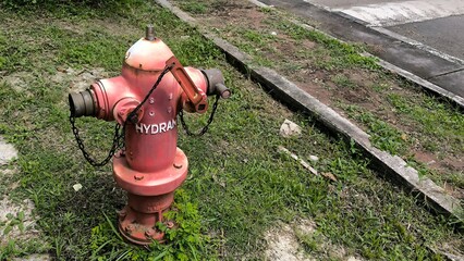 Red Fire Hydrant with Wrench on a Grassy Roadside for Emergency Water Supply