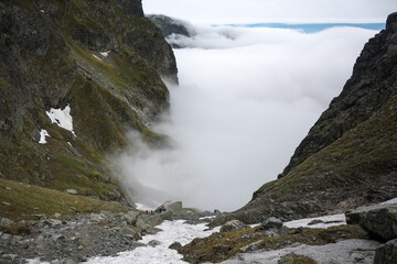 Clouds over the valley, a journey along a trail in the high mountains.
