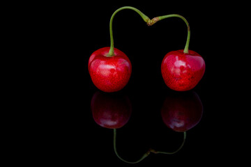 Fresh cherries on a black background with reflection. 