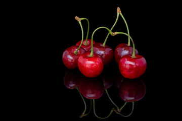 Fresh cherries on a black background with reflection. 