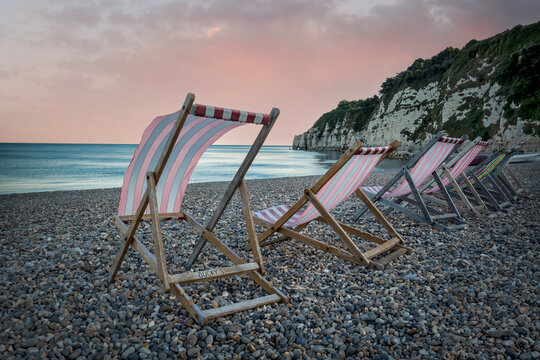 Line of deckchairs billowing in seaside breeze in Devon