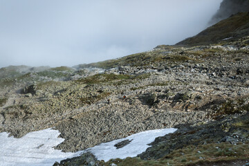 Small figures of tourists climbing on a high-altitude trail in the Tatra Mountains
