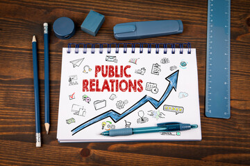 Public Relations Strategy with Doodles and Growth Arrow on Notepad in Office Environment
