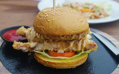Nice burger on hot plate on wooden table