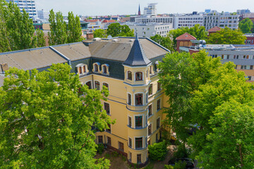 Aerial View Of Historic Yellow Building Surrounded By Green Trees In Berlin