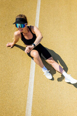 Athlete stretching on the track during early morning training session