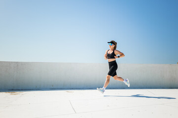 Energetic runner enjoys a sunny day on the rooftop training for a marathon