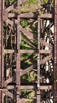 Aerial View of Rusted Steel Bridge Structure with Overgrown Vegetation