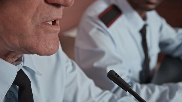 Cropped shot of mature male military officer in uniform giving speech during conference with colleagues