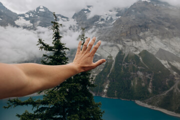 Woman Admiring Engagement Ring with Scenic Lake and Snow-Capped Mountains, Symbolizing Romantic Marriage Proposal