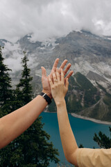 Woman Admiring Engagement Ring with Scenic Lake and Snow-Capped Mountains, Symbolizing Romantic Marriage Proposal
