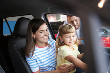 Happy family sitting inside new car. Luxury vehicle
