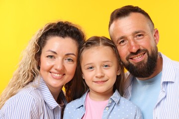 Fototapeta premium Portrait of happy family on yellow background