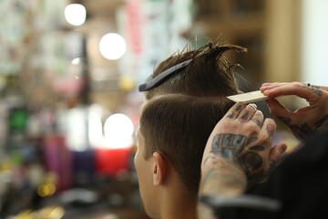 Fototapeta premium Professional barber working with client in barbershop, closeup. Space for text